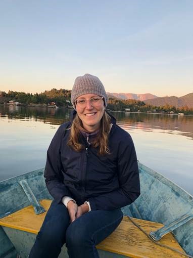 Graduate student Samantha Sharp sitting on a boat in a lake.