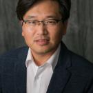 man wearing glasses and collared shirt with jacket