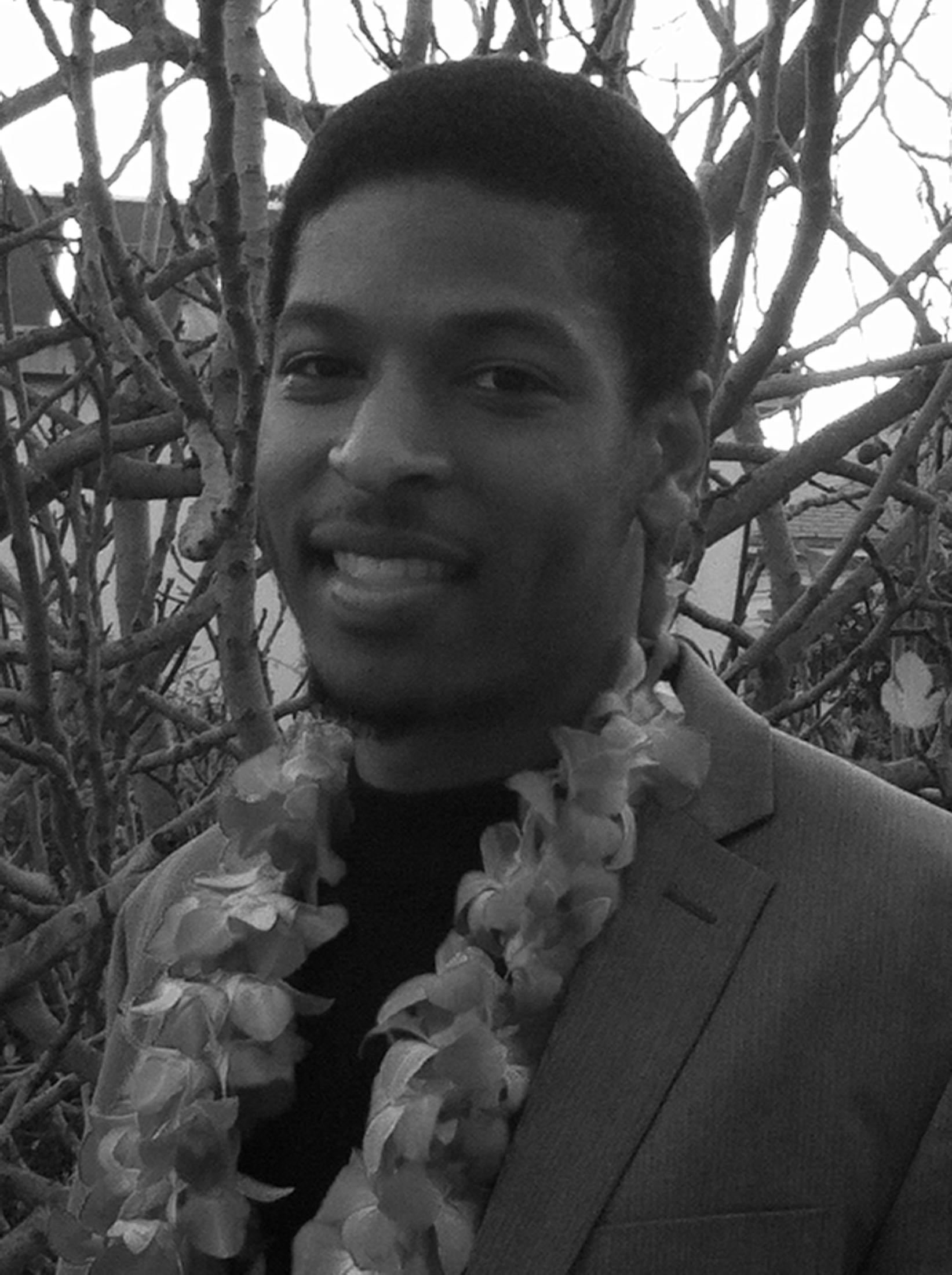 Photo of man smiling with lei around neck