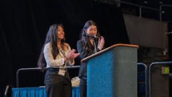 Two students speaking at a podium