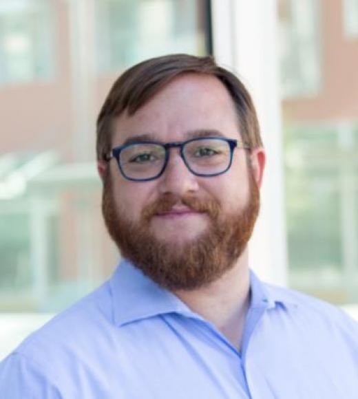 Photo of man with glasses and beard in front of window