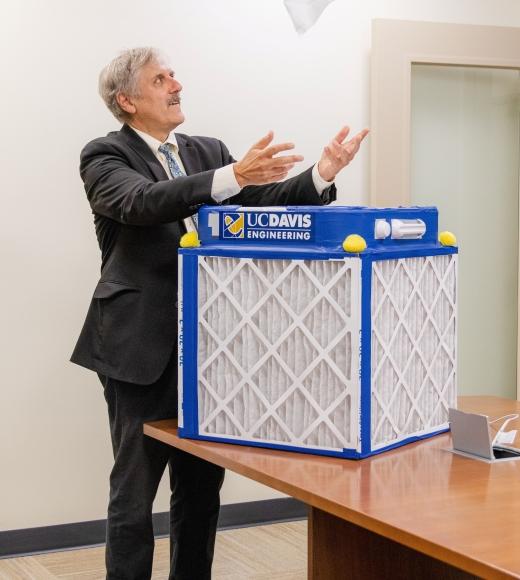 Richard Corsi presenting an air purifier with the UC Davis Engineering logo