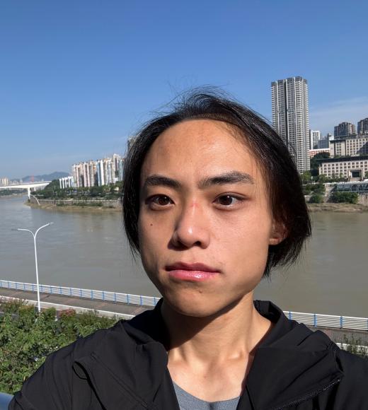 Yicheng taking a selfie with a city in the background and a river running through