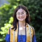 A woman wearing a UC Davis stole smiles